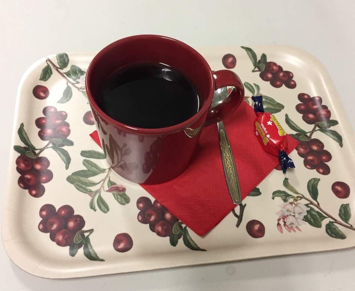 Punainen kahvimuki ja Dumle-karkki pöydällä