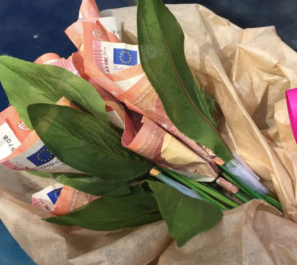Kimppu kymmenen euron seteleistä tehtyjä kukkia